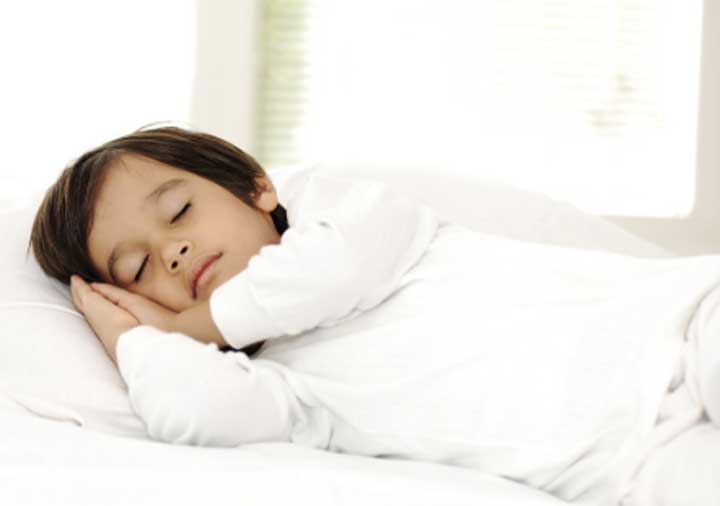 Young boy napping in brightly lit room