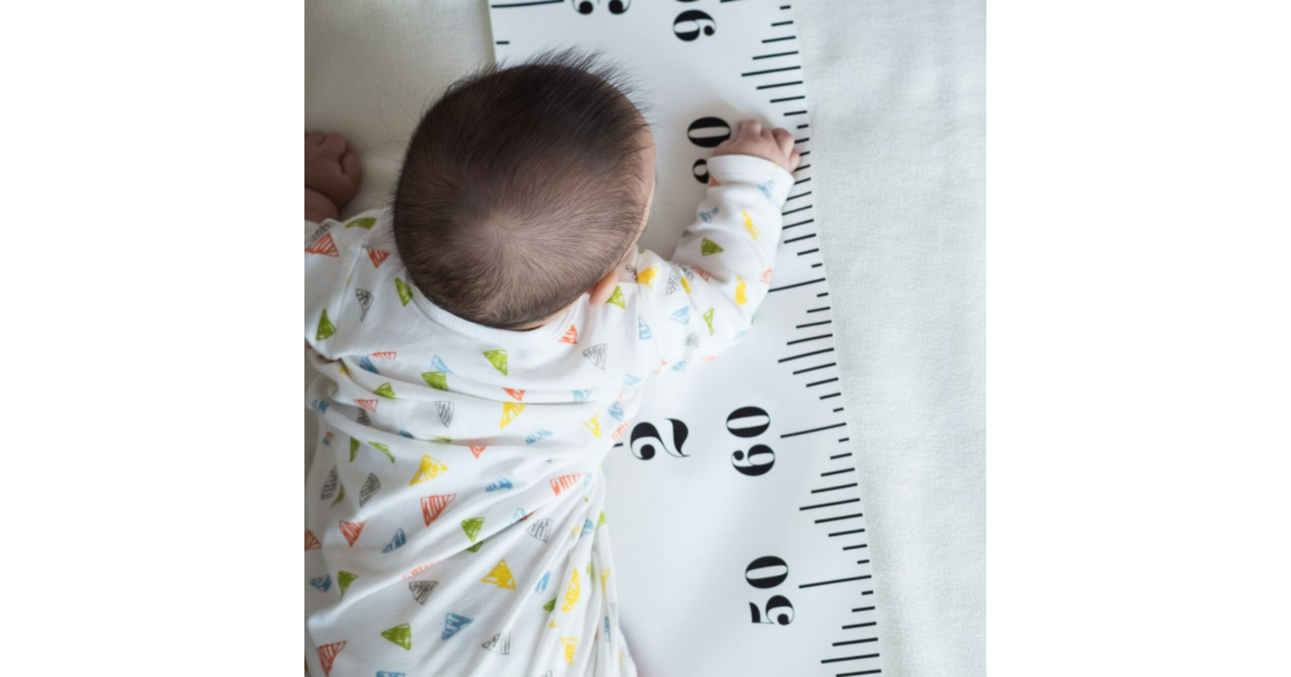 growth spurts - photo of a baby laying on her tummy beside a ruler