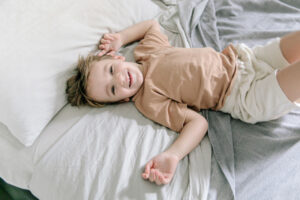 Toddler clock tips: Child lying on bed as viewed from above.
