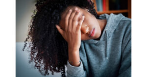 Anxiety around sleep training... a person with long hair covering her eyes looking nervous or defeated or anxious
