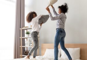 Mom and teen pillow fighting - showing how teans play