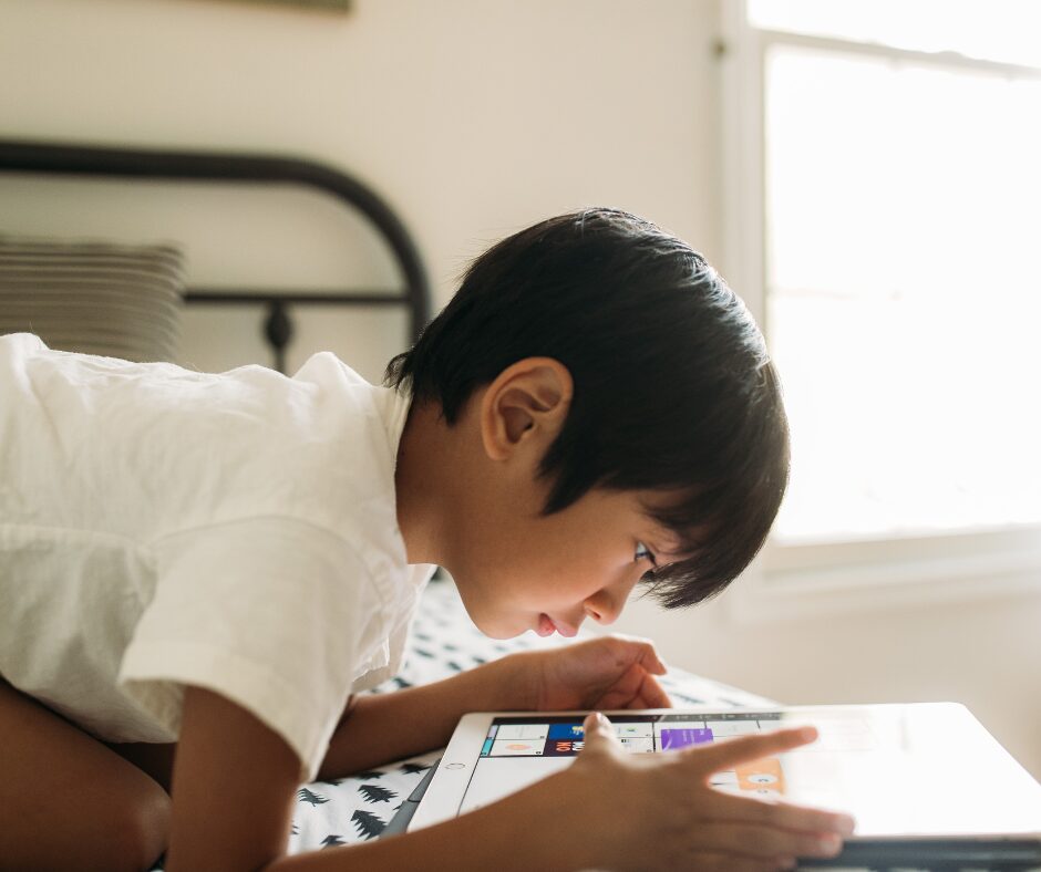 screentime - a child leaning over an iPad